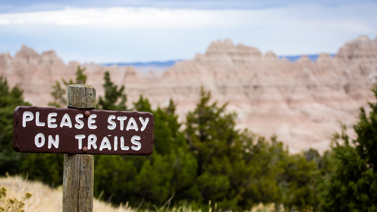 Sign stating "Please Stay in Trails"